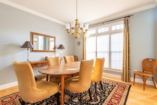 dining room featuring light wood finished floors, ornamental molding, and baseboards