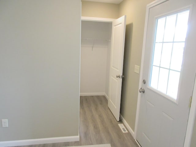 interior space featuring visible vents, light wood-style flooring, and baseboards