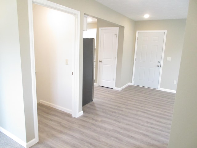 spare room featuring baseboards and light wood-style floors