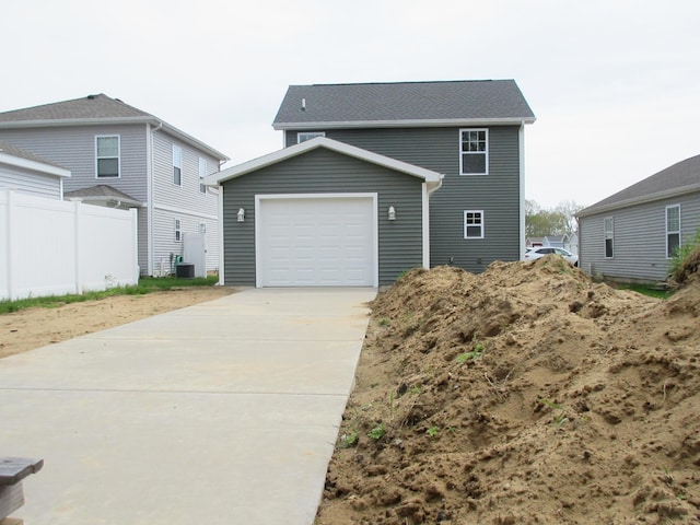 view of front of house featuring a garage, driveway, and fence