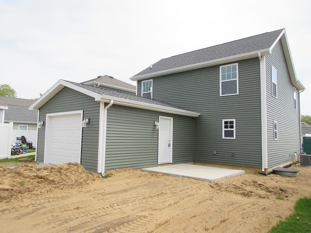 rear view of property with a patio area and an attached garage