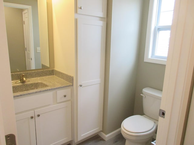 bathroom featuring vanity, toilet, and baseboards