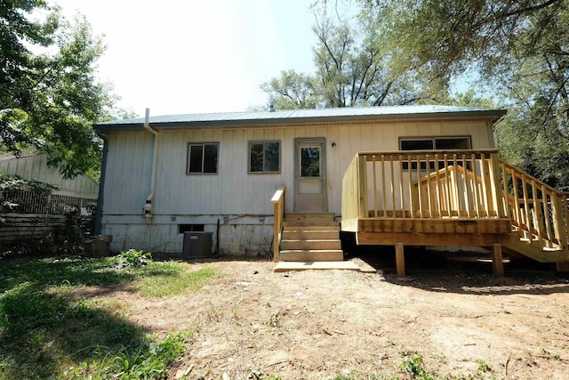 rear view of house featuring central AC, metal roof, and a deck