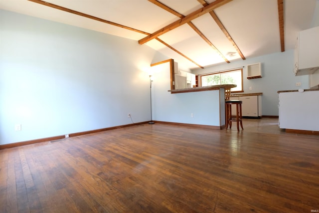 unfurnished living room featuring vaulted ceiling with beams, hardwood / wood-style flooring, and baseboards