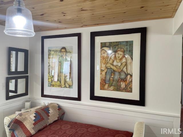 bedroom with wood ceiling and wainscoting