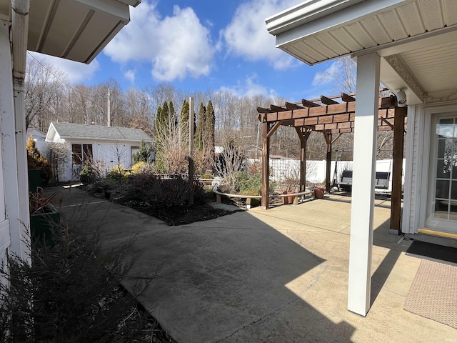 view of patio featuring a pergola and an outbuilding