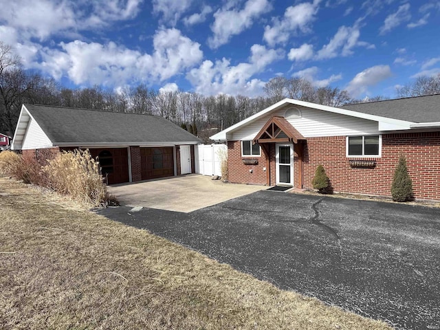 ranch-style home featuring a garage, brick siding, and a shingled roof