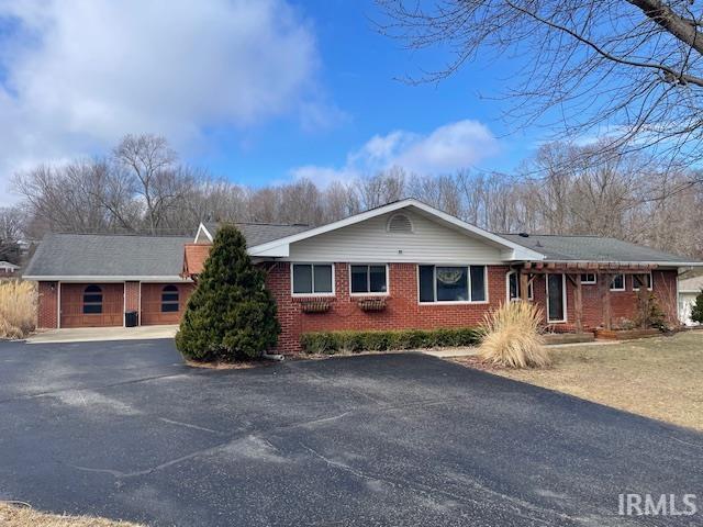 single story home featuring driveway and brick siding