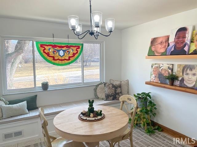 dining space featuring a chandelier, visible vents, and baseboards