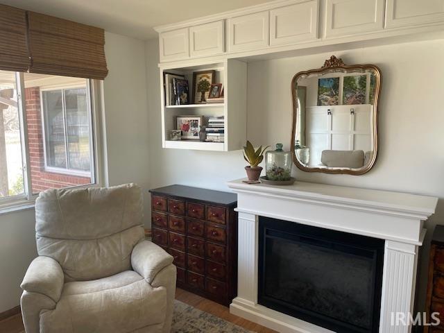 sitting room with wood finished floors and a glass covered fireplace