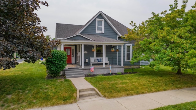 view of front facade featuring covered porch, roof with shingles, and a front yard