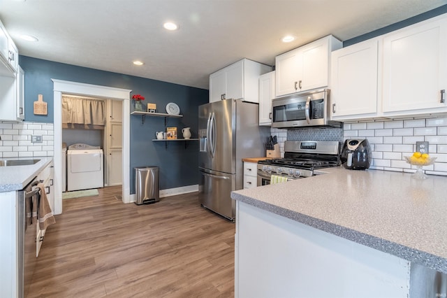 kitchen with open shelves, light countertops, appliances with stainless steel finishes, light wood-style floors, and white cabinetry