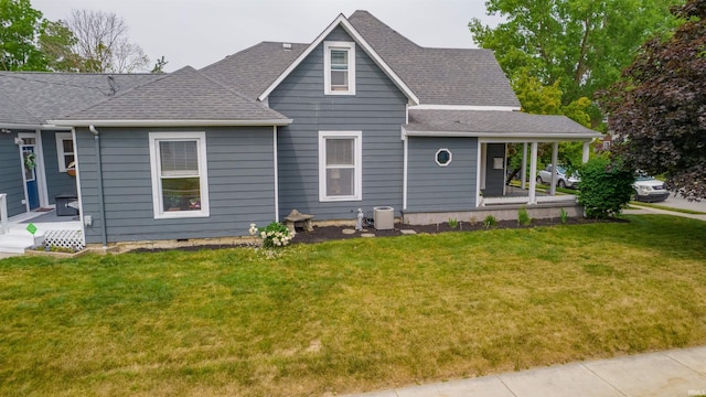 view of front of property with a porch, a front lawn, cooling unit, and roof with shingles