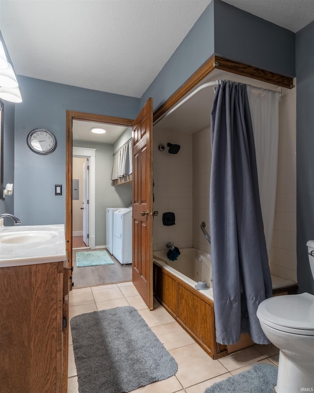 full bath featuring washer and clothes dryer, shower / bath combination with curtain, toilet, vanity, and tile patterned floors