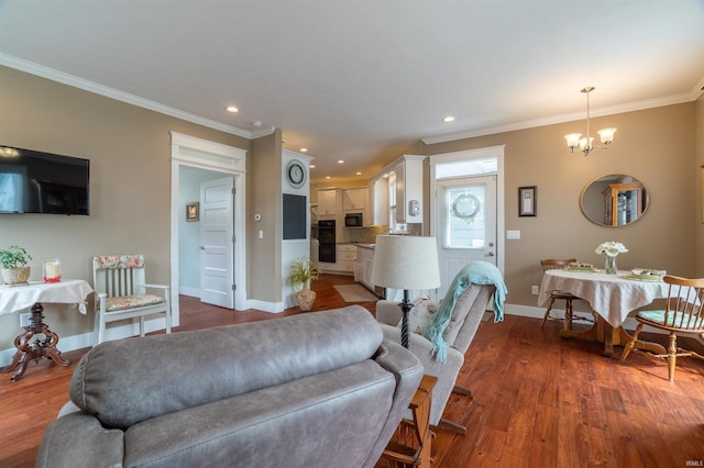 living area featuring recessed lighting, a notable chandelier, wood finished floors, baseboards, and ornamental molding