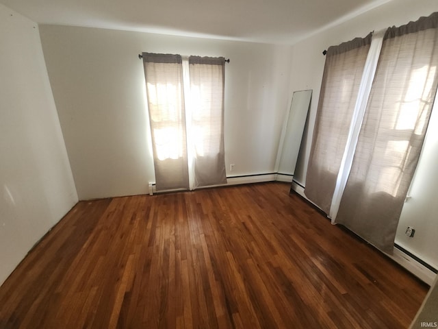 empty room featuring dark wood-style flooring and a baseboard radiator