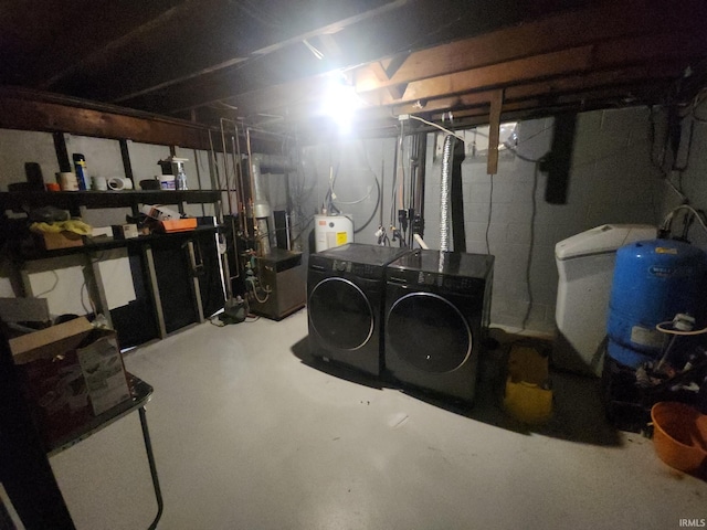 unfinished basement featuring a heating unit, water heater, and washing machine and clothes dryer