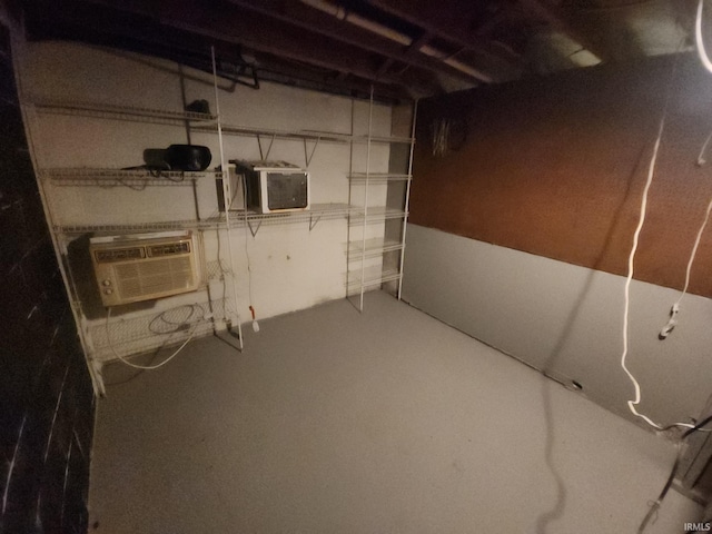 unfinished basement featuring an AC wall unit