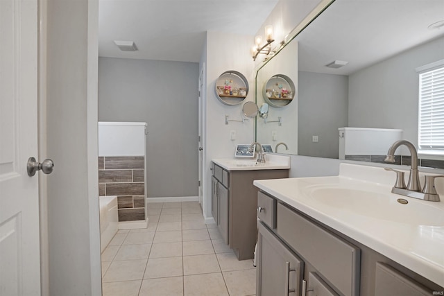 bathroom featuring a garden tub, two vanities, tile patterned flooring, and a sink