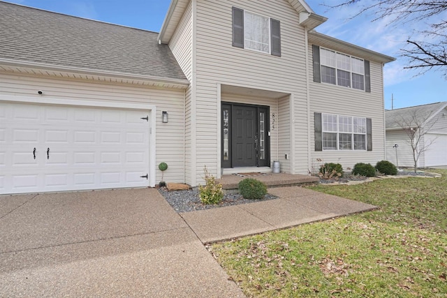 traditional home with a garage, concrete driveway, a shingled roof, and a front lawn