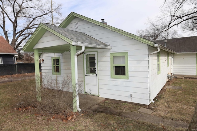 exterior space featuring a shingled roof and fence