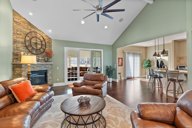 living area featuring a fireplace, baseboards, vaulted ceiling, and wood finished floors