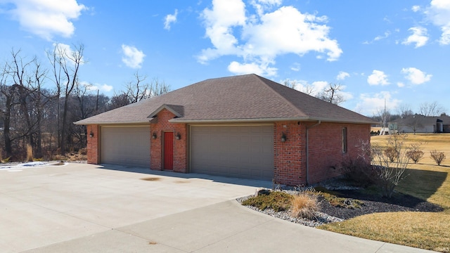 ranch-style home with a garage, brick siding, and a shingled roof