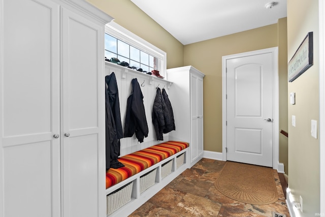 mudroom featuring baseboards and stone finish floor