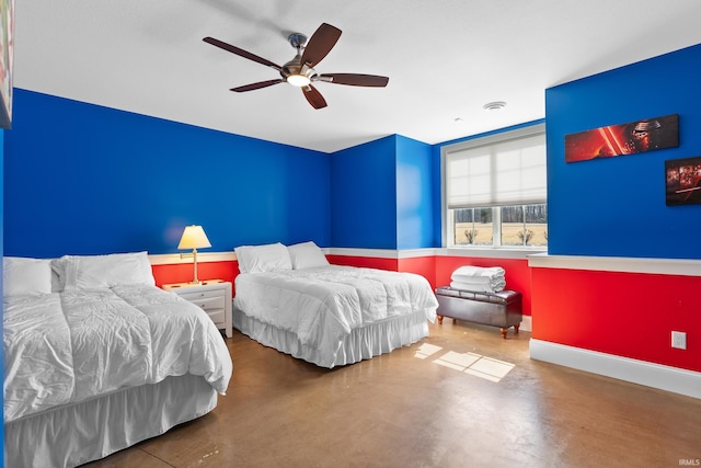 bedroom with ceiling fan, finished concrete flooring, and baseboards