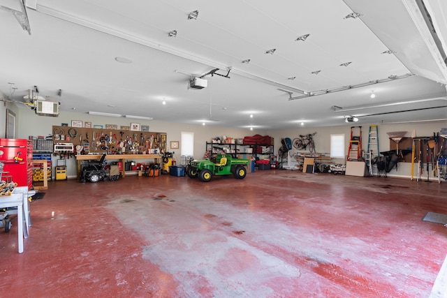 garage with a garage door opener and a workshop area