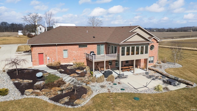 back of property with a patio, brick siding, and a lawn