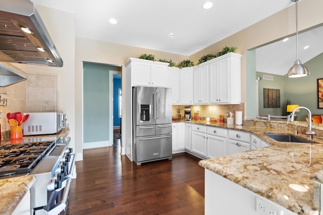 kitchen featuring high end appliances, wall chimney exhaust hood, light stone counters, dark wood-type flooring, and a sink