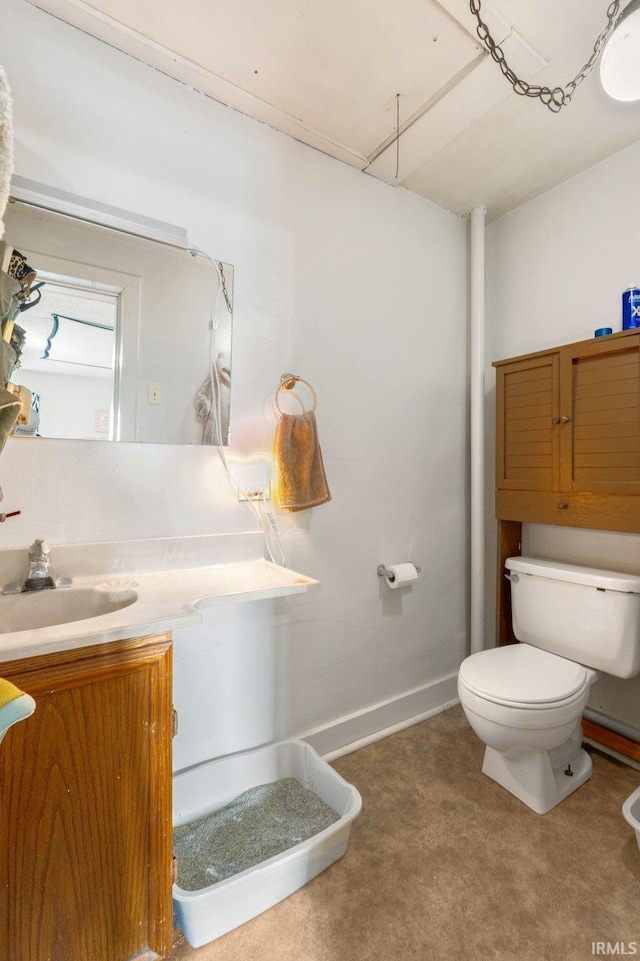 half bath with vanity, toilet, and baseboards