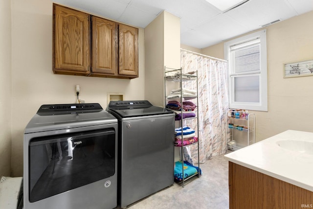 laundry area featuring visible vents, independent washer and dryer, and a sink