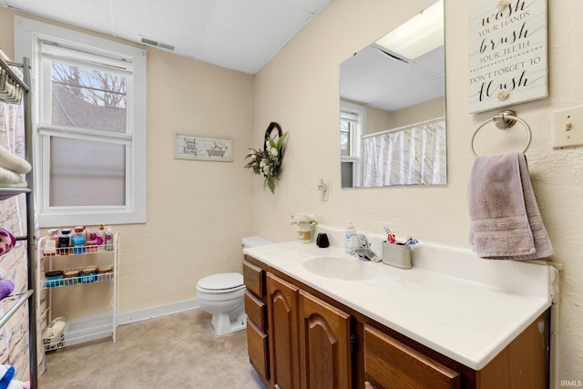 bathroom featuring toilet, vanity, visible vents, and baseboards