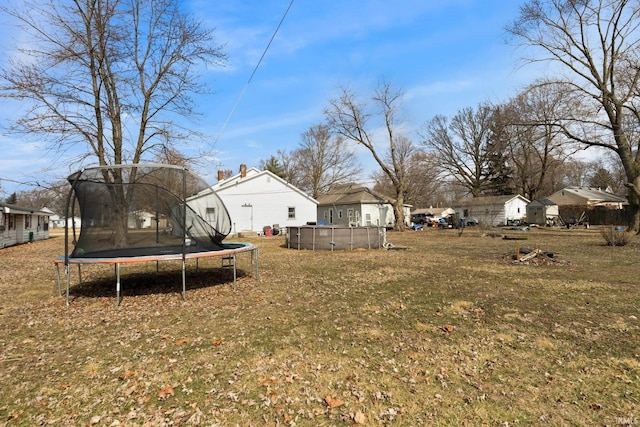 view of yard featuring a trampoline and a swimming pool