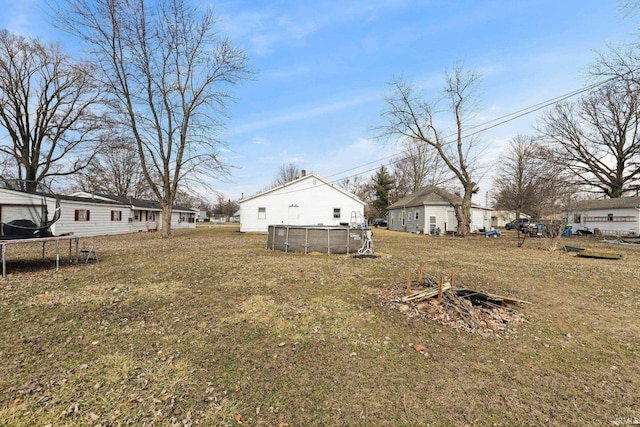 view of yard featuring a trampoline and an outdoor pool