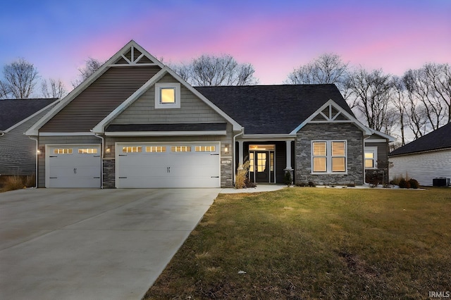 craftsman-style house with a garage, concrete driveway, stone siding, and a front lawn