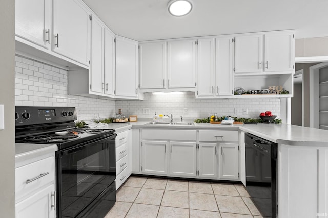 kitchen featuring black appliances, backsplash, light countertops, and a sink