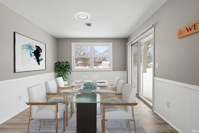 dining room with wainscoting, wood finished floors, and visible vents