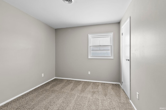 empty room with carpet floors, visible vents, and baseboards