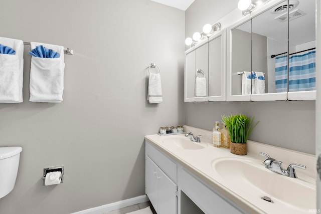 full bath with double vanity, a sink, visible vents, and baseboards