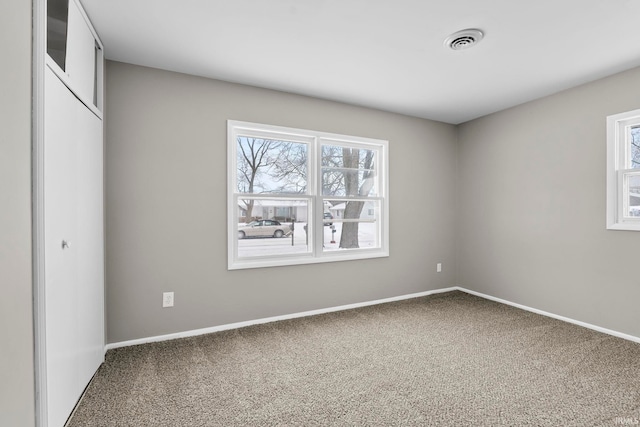 unfurnished bedroom featuring carpet flooring, visible vents, and baseboards