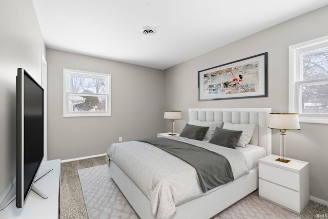 bedroom with light carpet, multiple windows, and visible vents