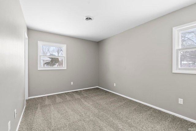 carpeted empty room featuring visible vents and baseboards