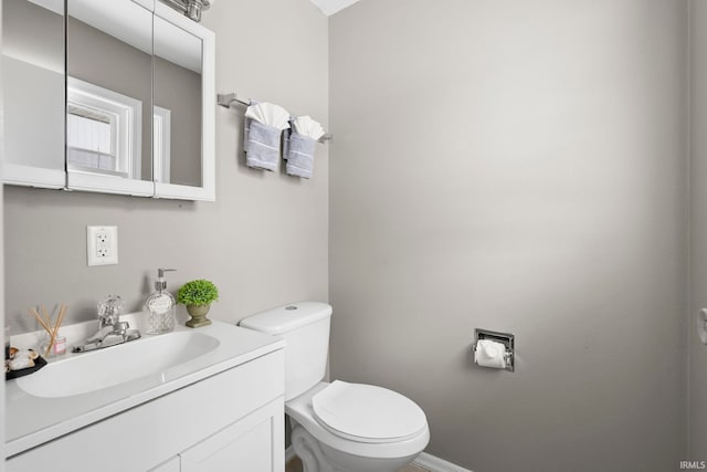 bathroom with vanity, toilet, and baseboards