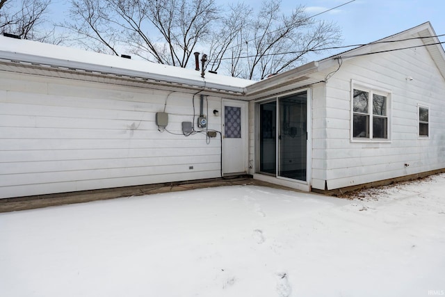 view of snow covered rear of property