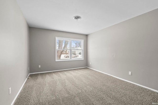 empty room with carpet flooring, visible vents, and baseboards