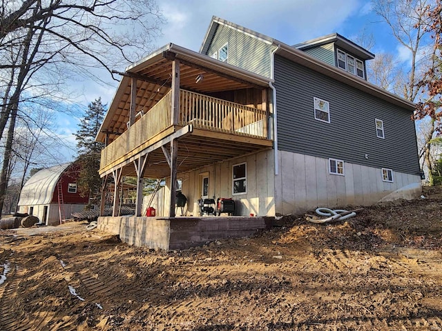 rear view of house with a wooden deck and a patio