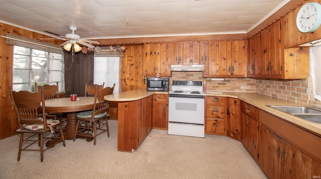 kitchen with under cabinet range hood, white electric range, a peninsula, light countertops, and brown cabinetry